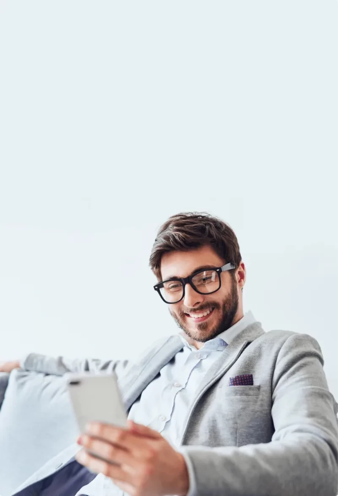 Man sitting on sofa looking at phone with a smile
